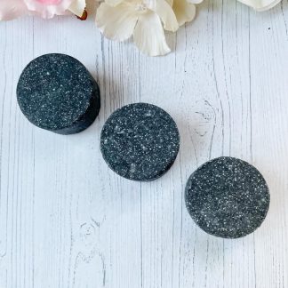 Shampoing solide charbon actif fait main, purifiant et naturel, idéal pour équilibrer le cuir chevelu et absorber l'excès de sébum.