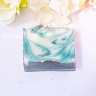 Savon artisanal Amazon Rain posé sur un fond naturel avec feuilles tropicales